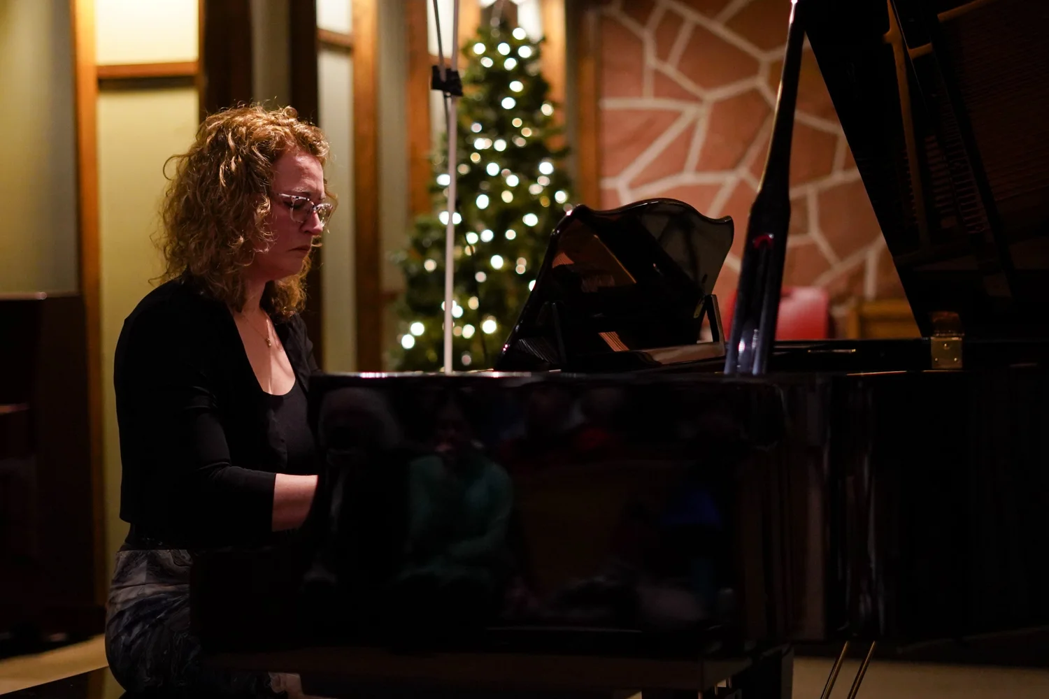 Une élève adulte joue du piano à queue lors d’un concert PianoPiano!