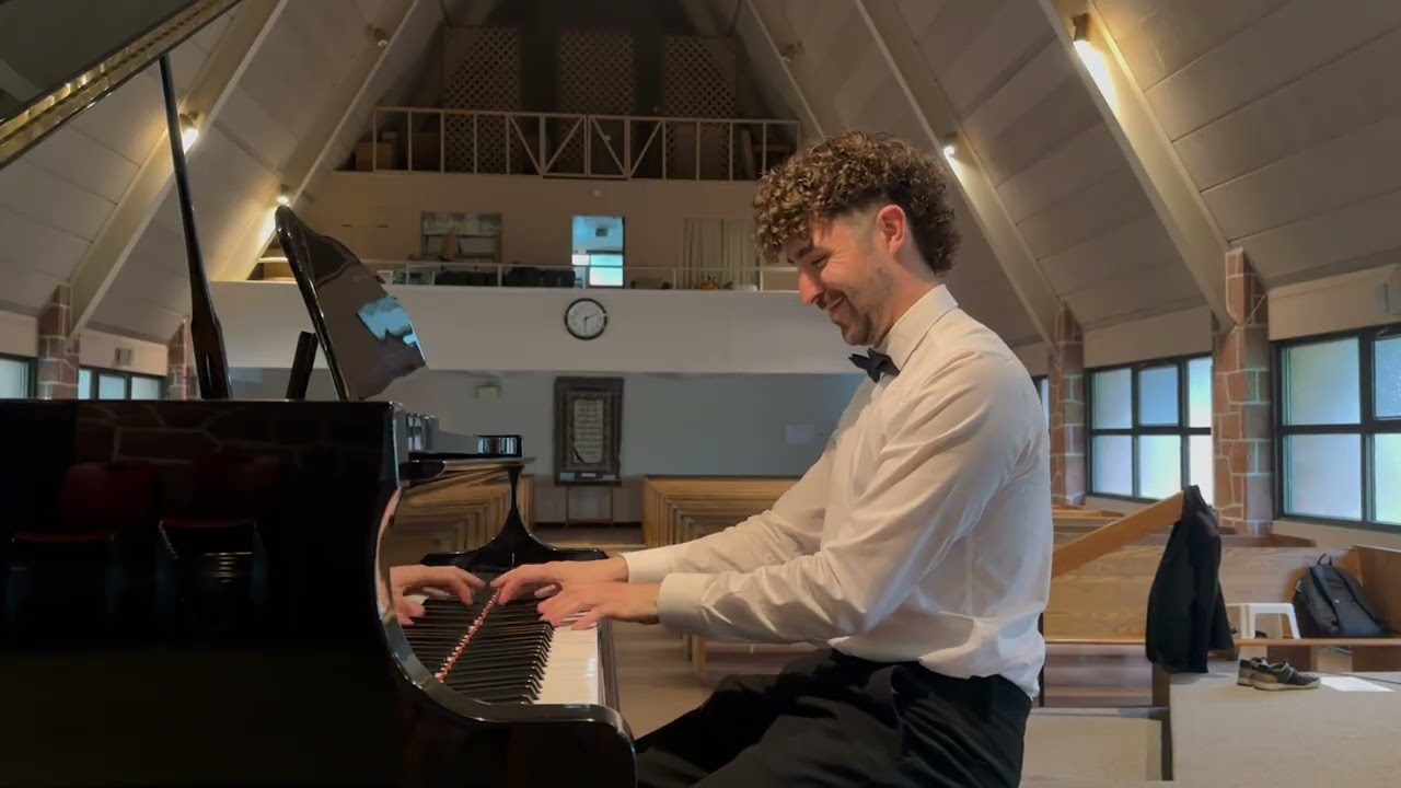 Jean-Baptiste Gleize sourit en essayant le piano dans une salle de concert